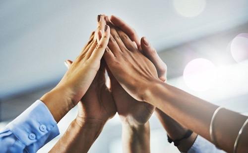 people's hands in high five of negotiation